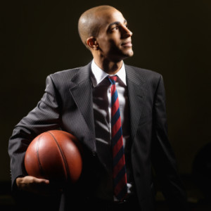 Contemplative businessman holding a basket ball in his hand